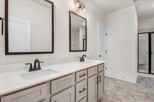 a bathroom with double sink and a mirror