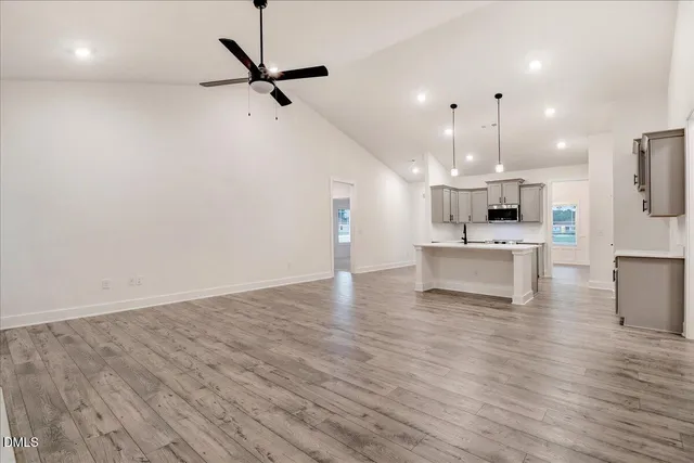 a view of a kitchen with sink microwave and cabinets
