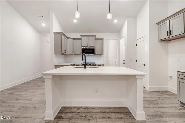a kitchen with kitchen island a sink stainless steel appliances and cabinets