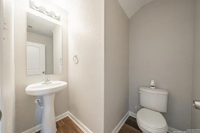a bathroom with a granite countertop sink a toilet and shower