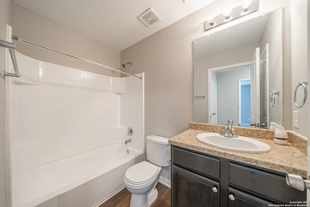 a bathroom with a granite countertop sink toilet and shower
