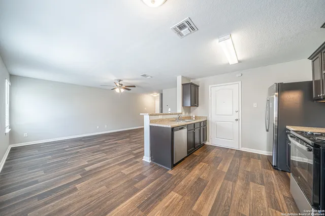 a kitchen with granite countertop a sink stove and refrigerator