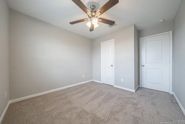 an empty room with fan and windows