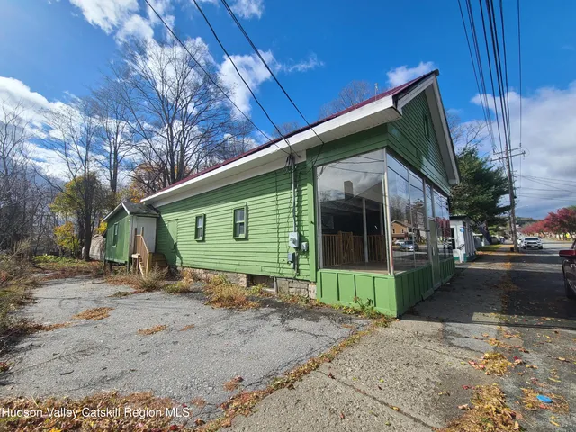 a view of a house with a yard and potted plants