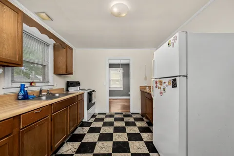 a kitchen with a sink a refrigerator and cabinets