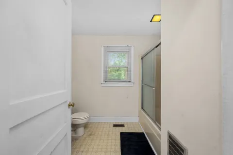 a bathroom with a toilet and a shower