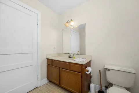 a bathroom with a toilet a sink and mirror