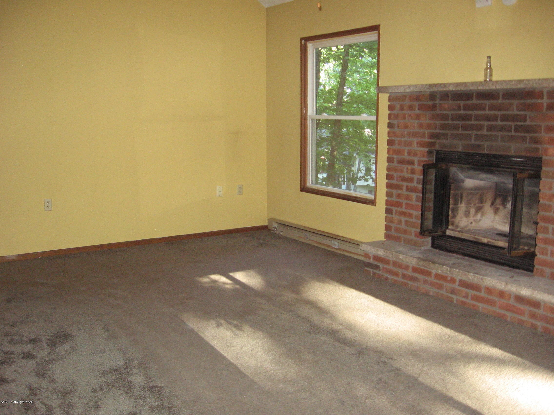 142 Doe Loop Bushkill, PA 18324 - Photo 7 of 10 a view of an empty room with a fireplace and a window