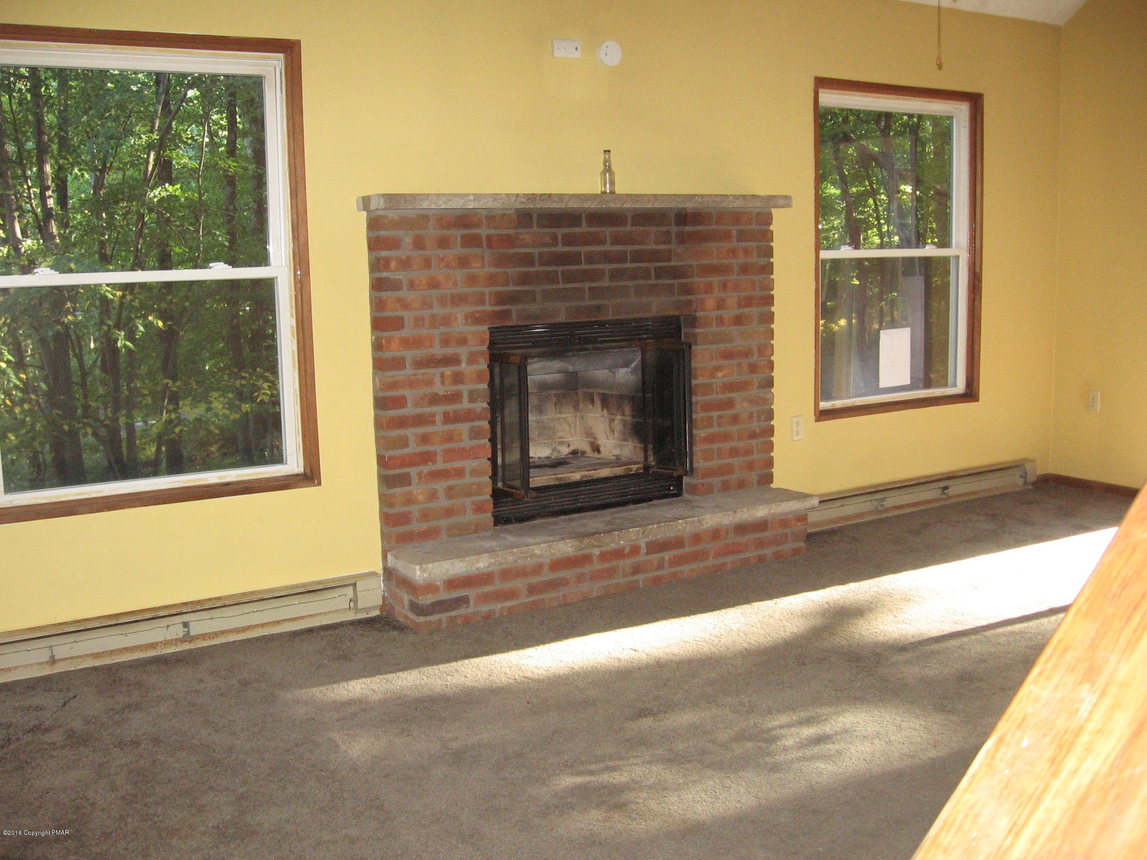 142 Doe Loop Bushkill, PA 18324 - Photo 10 of 10 a living room with a fireplace and a floor to ceiling window