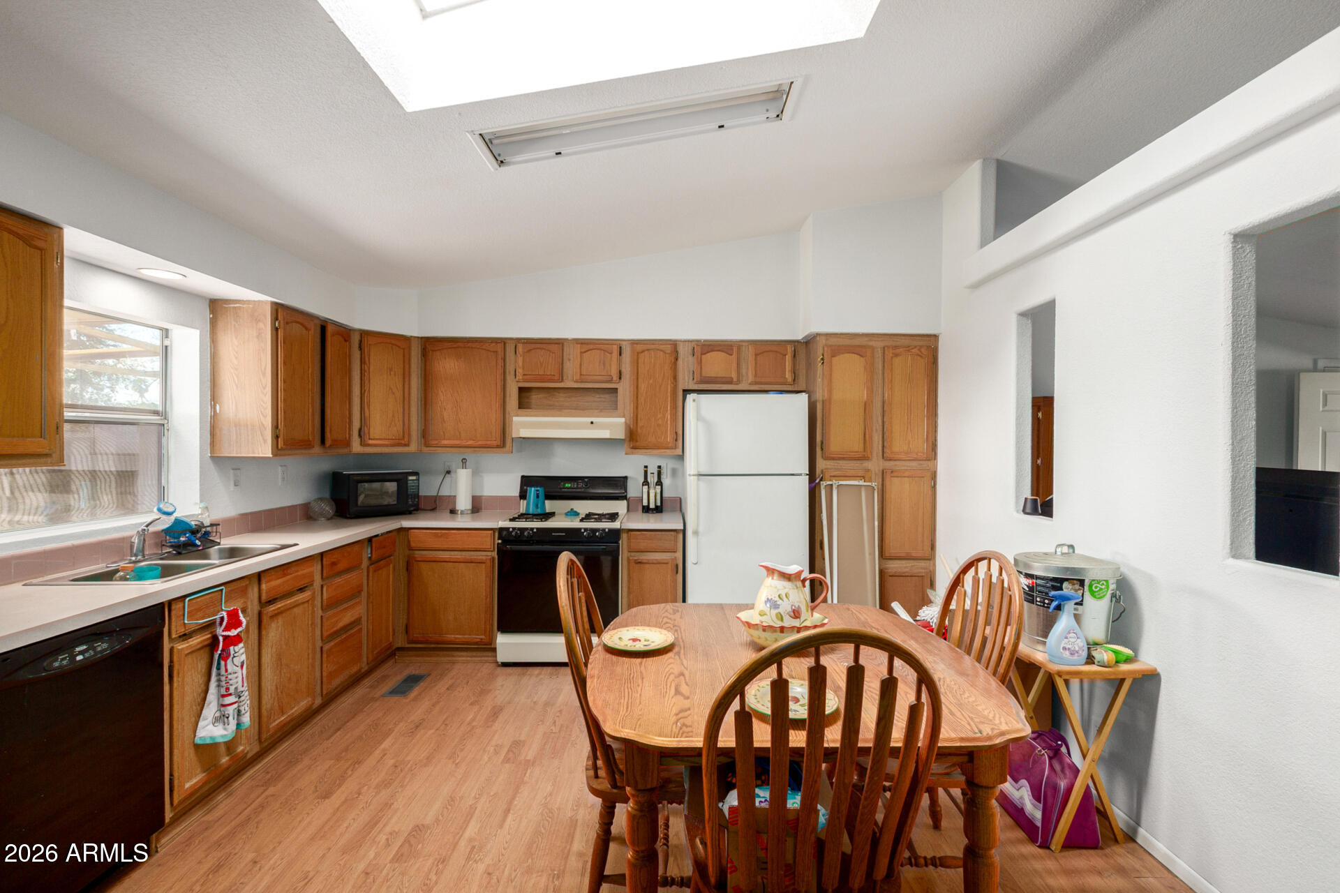 6751 West Nancy Road Peoria, AZ 85382 - Photo 11 of 29 a kitchen with stainless steel appliances granite countertop a stove a sink a dining table and chairs