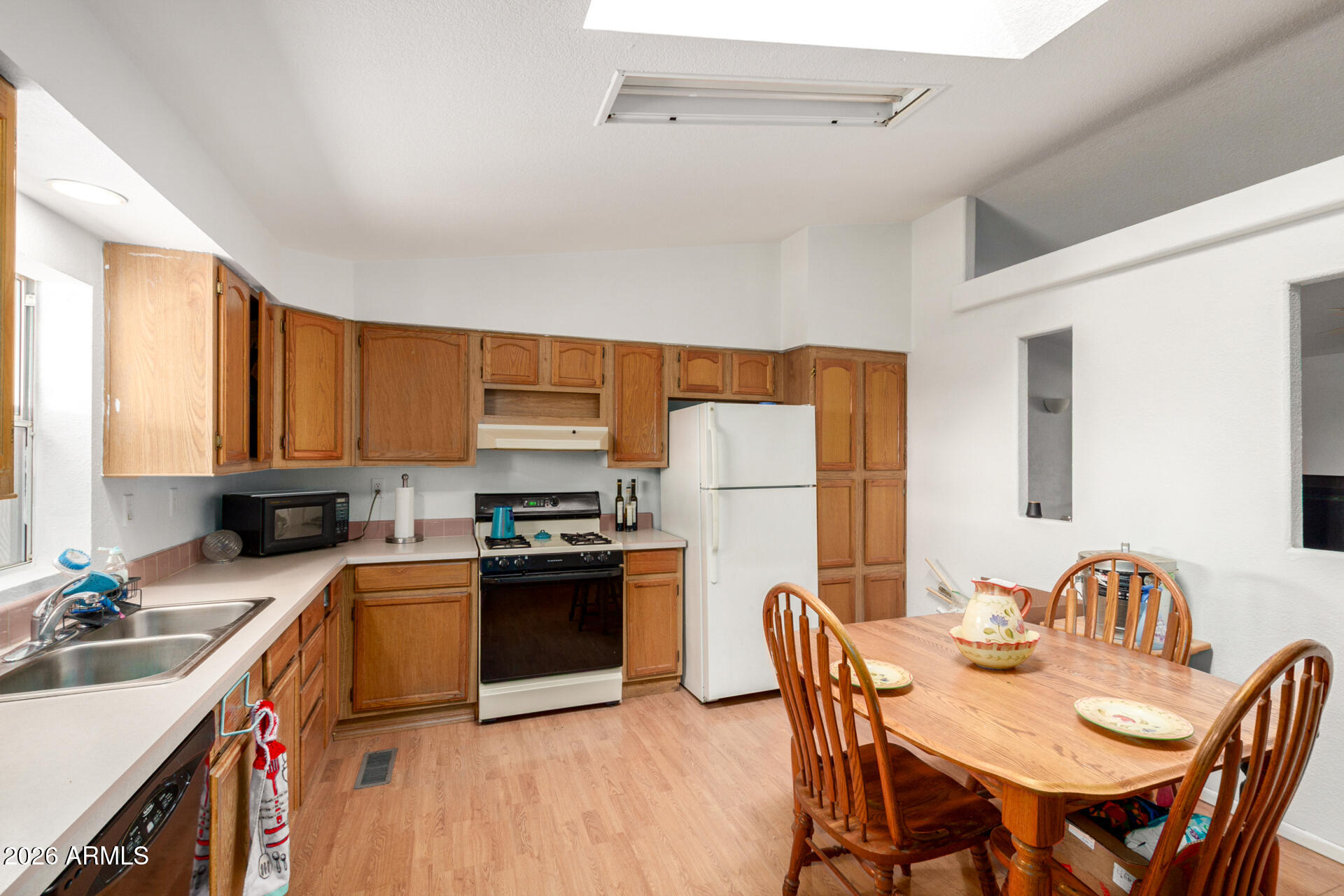 6751 West Nancy Road Peoria, AZ 85382 - Photo 12 of 29 a kitchen with stainless steel appliances granite countertop a kitchen island hardwood floor sink stove dining table and chairs