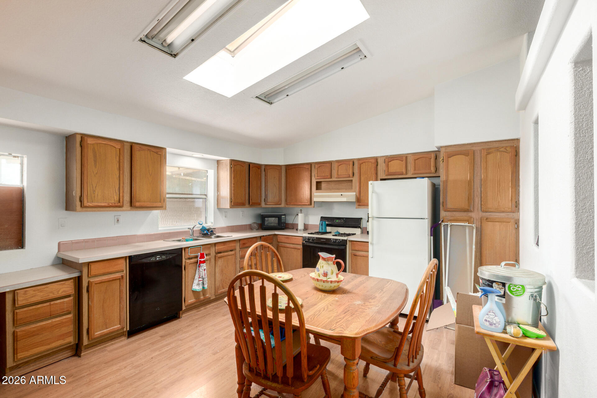 6751 West Nancy Road Peoria, AZ 85382 - Photo 10 of 29 a kitchen with stainless steel appliances granite countertop a dining table chairs refrigerator and sink