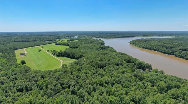 an aerial view of a house with a yard and lake view