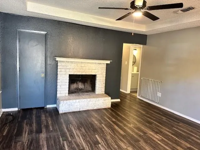 a living room with wooden floors and a fireplace