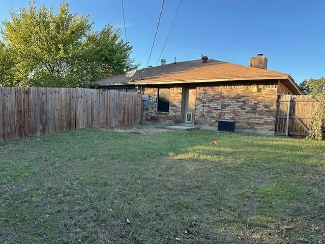 a view of a backyard with a small cabin and wooden fencing