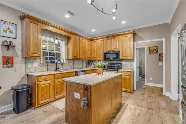 a kitchen with stainless steel appliances granite countertop sink stove top oven and refrigerator