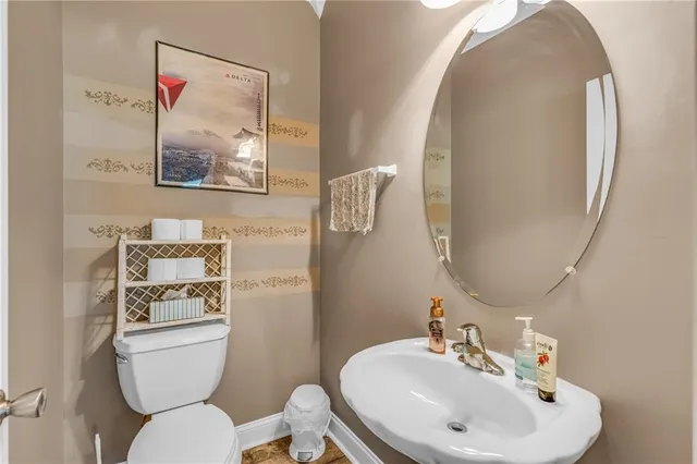 a bathroom with a toilet a sink and mirror