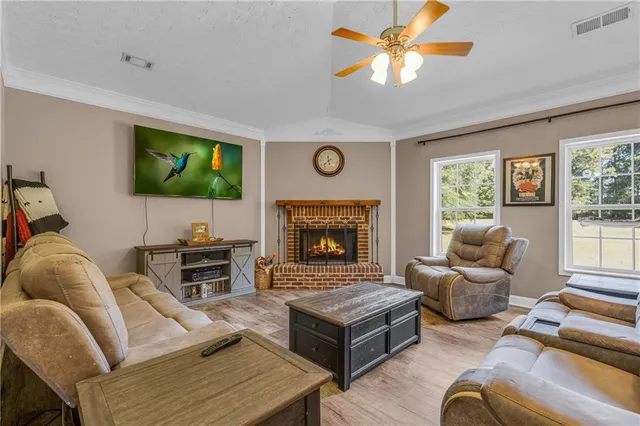 a living room with furniture a flat screen tv and a fireplace