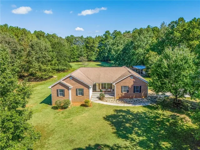 a aerial view of a house with yard and green space