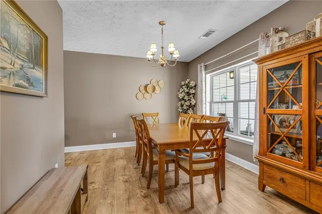 a view of a dining room with furniture a chandelier and wooden floor