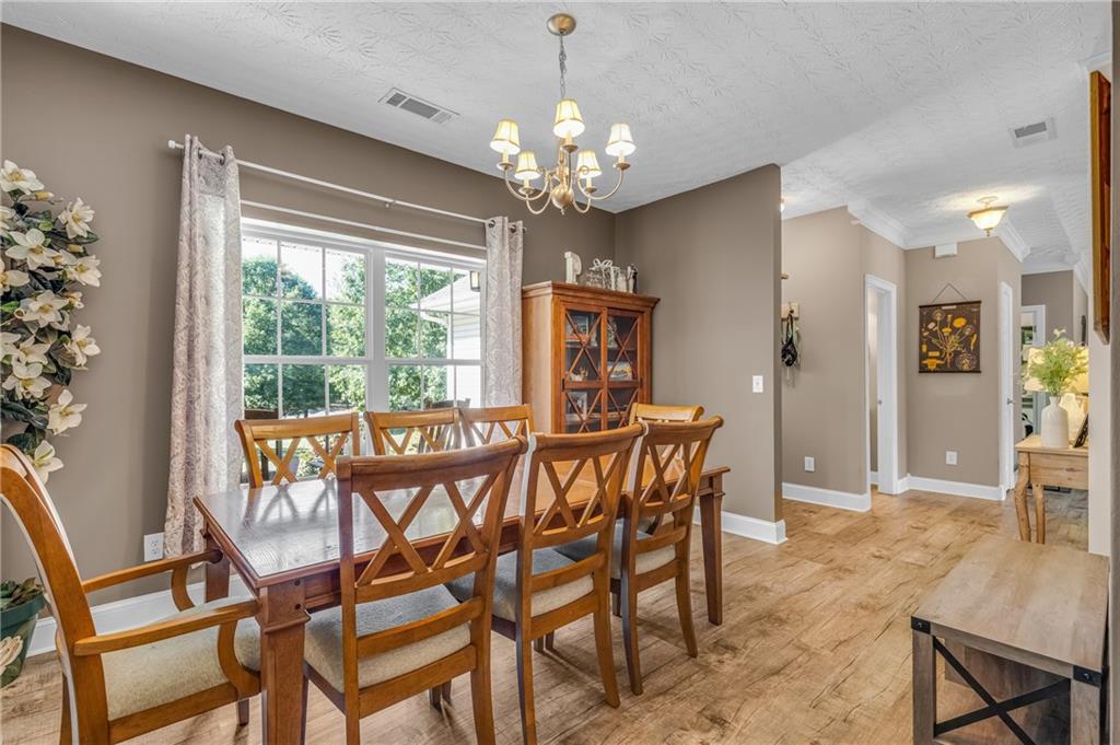 141 High Ridge Trail Jackson, GA 30233 - Photo 7 of 35 a view of a dining room with furniture a chandelier and wooden floor