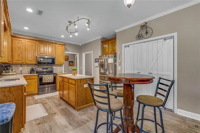 a kitchen with stainless steel appliances kitchen island granite countertop a sink and cabinets