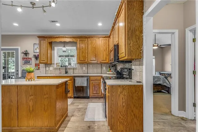 a kitchen with a sink appliances cabinets and a counter top space