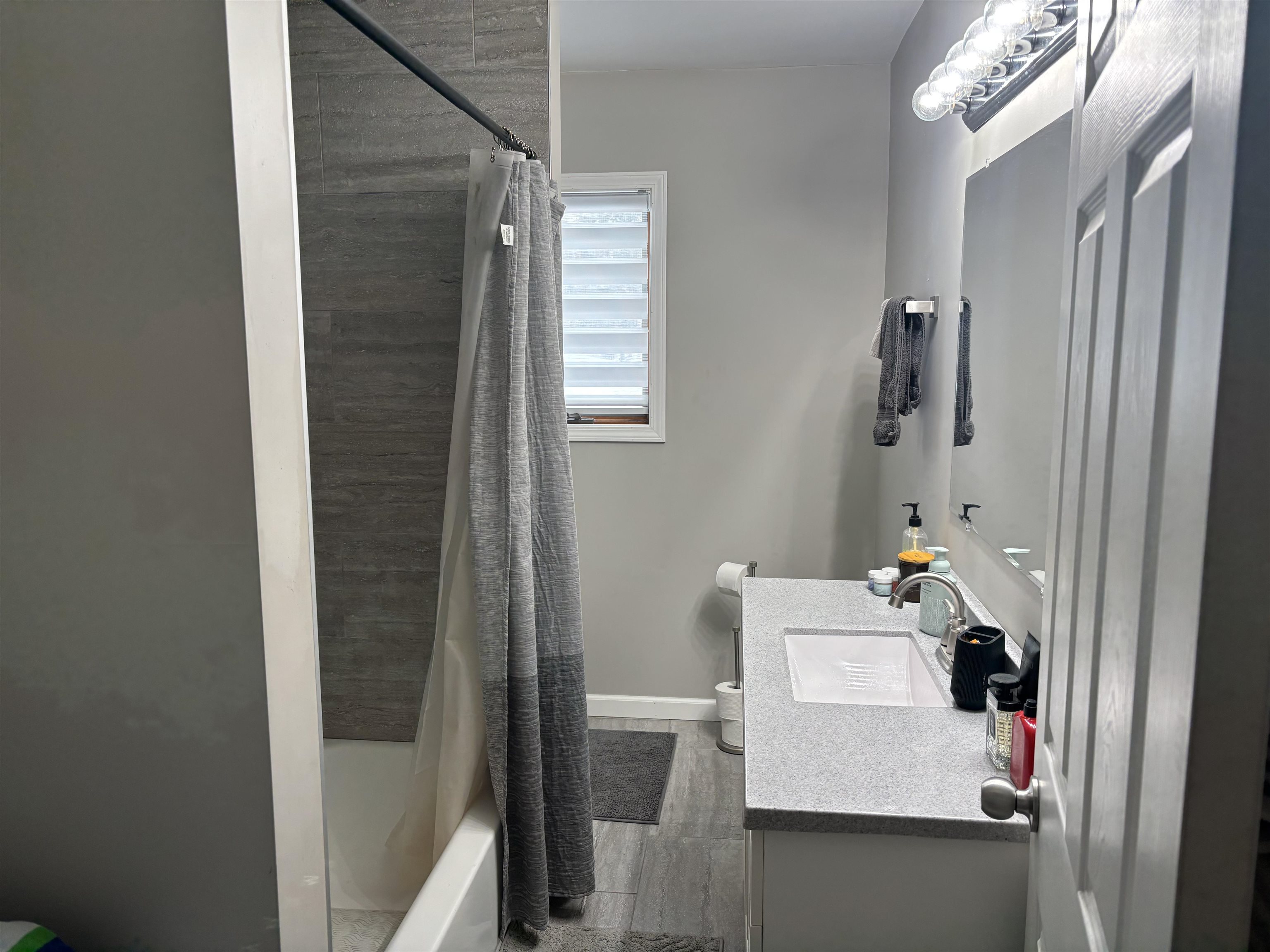 9688 Highway 37 Iron, MN 55751 - Photo 12 of 14 Bathroom featuring vanity, shower / tub combo with curtain, and wood finished floors