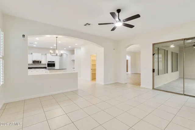 a view of a tennis ground with a table and chairs under an umbrella