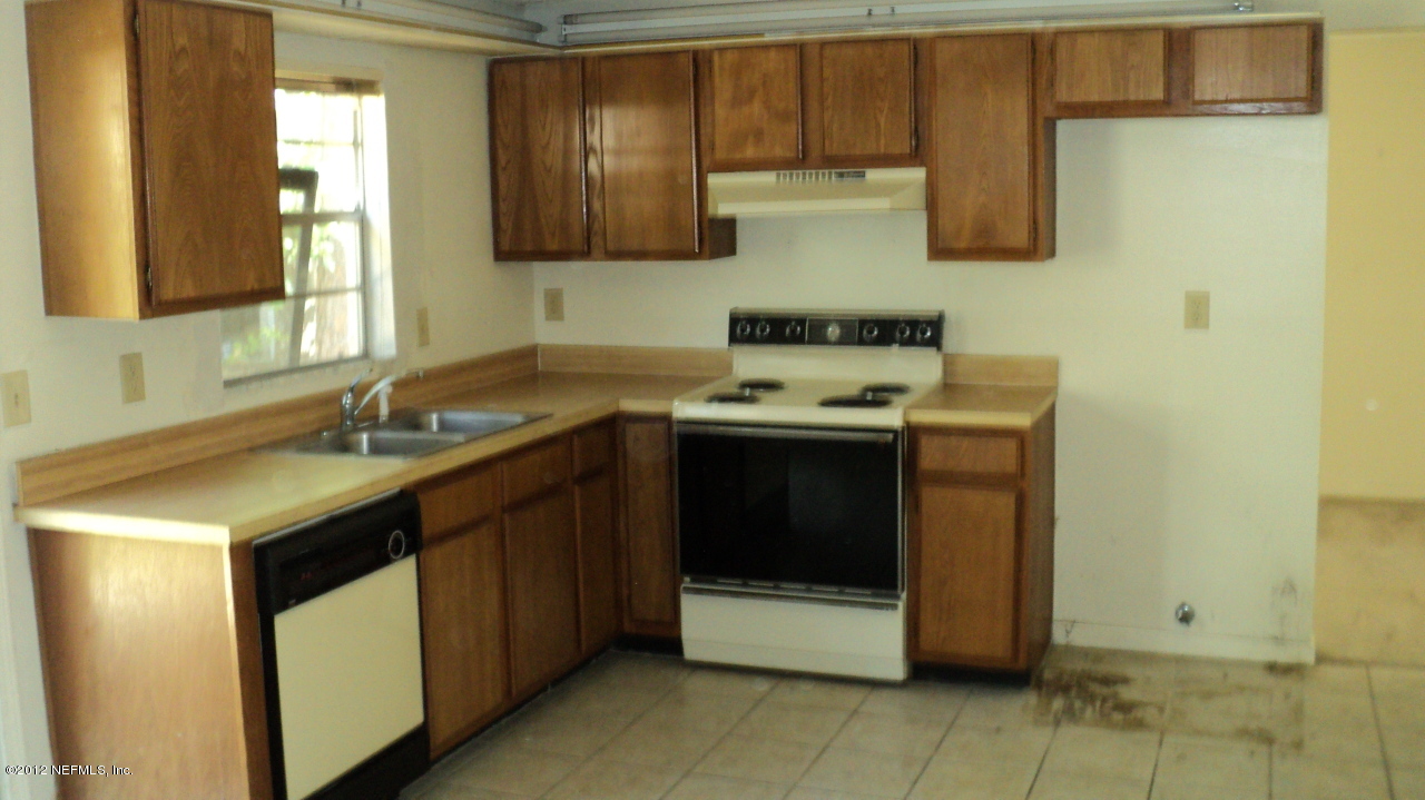 3223 Ricky Drive Jacksonville, FL 32223 - Photo 6 of 25 a kitchen with a sink stove and cabinets