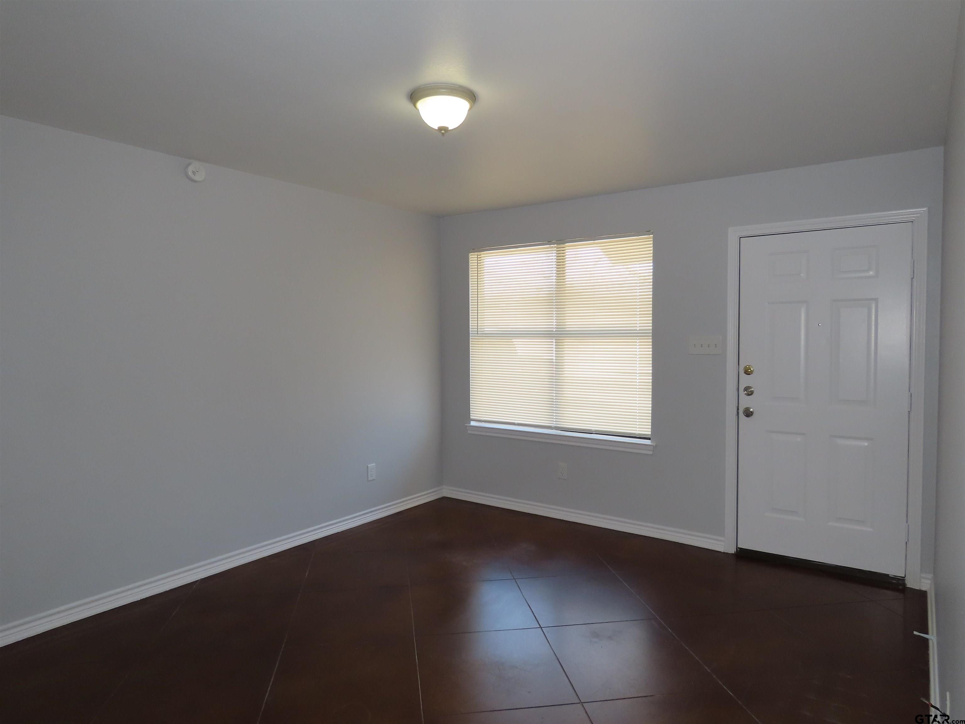 203 Memory Lane, Unit D Whitehouse, TX 75791 - Photo 3 of 16 an empty room with wooden floor and windows