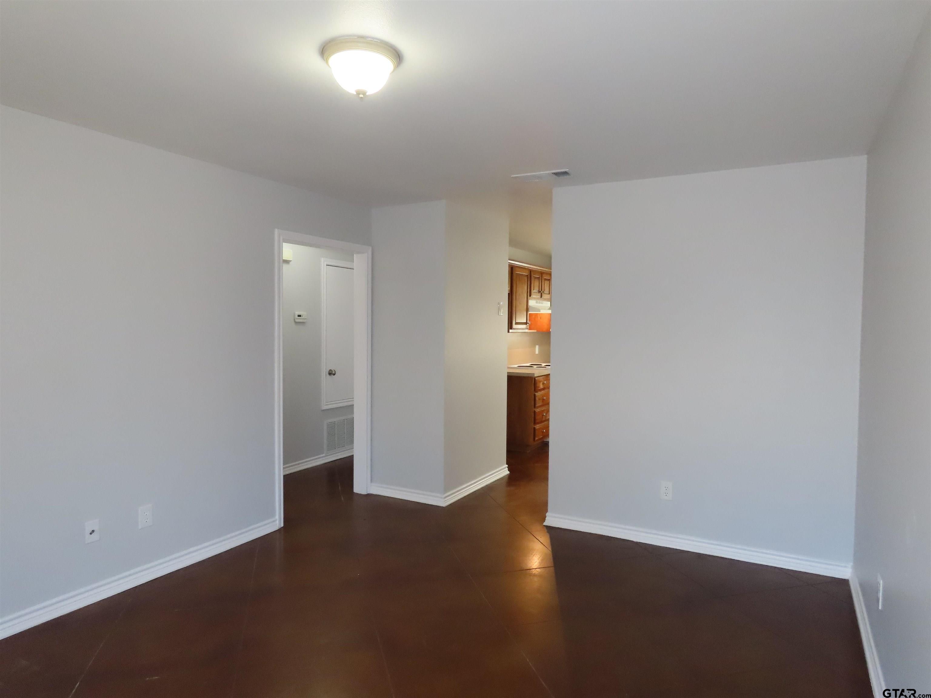 203 Memory Lane, Unit D Whitehouse, TX 75791 - Photo 6 of 16 a view of an empty room with wooden floor and a window