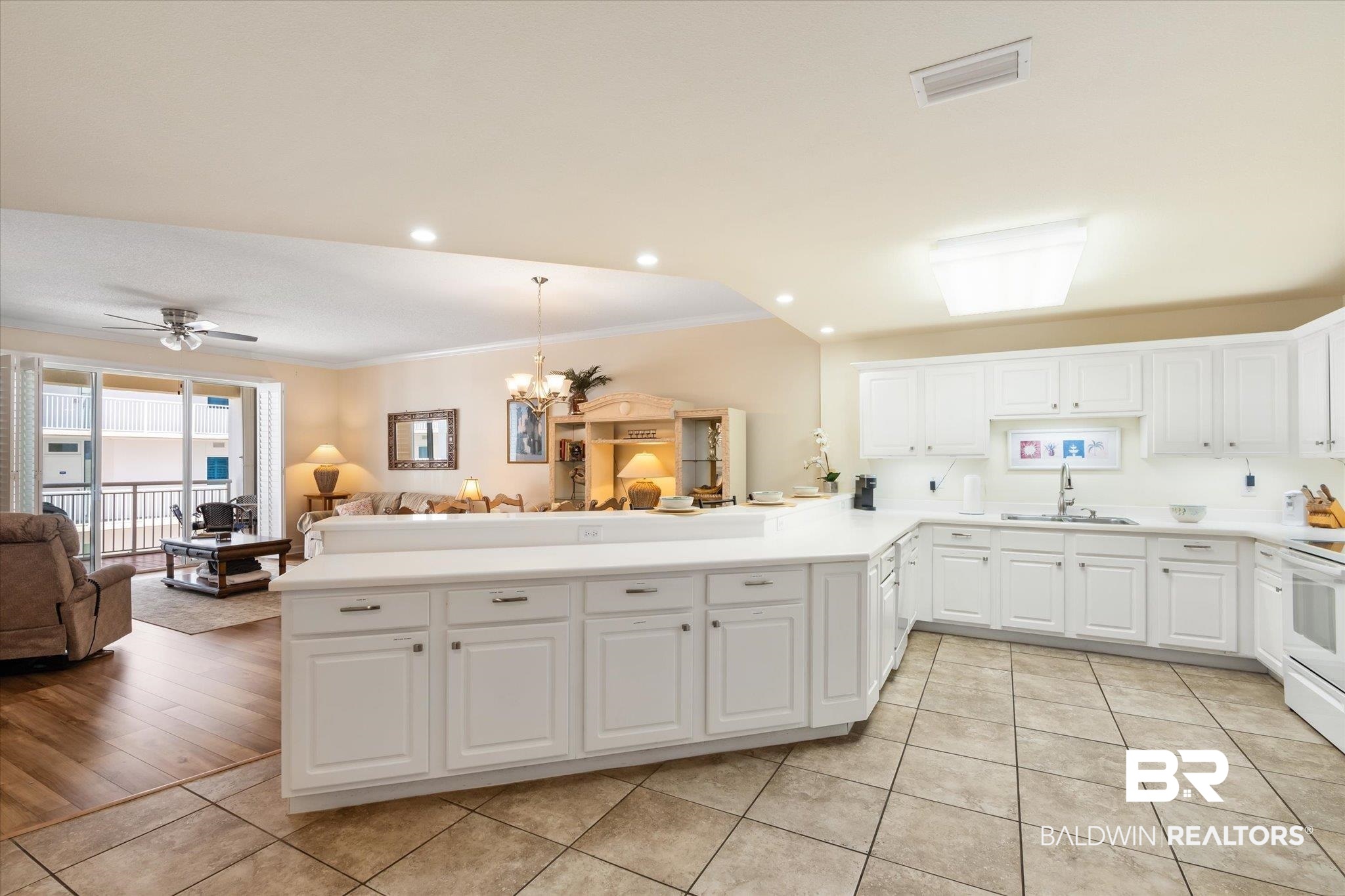 27770 Canal Road, Unit 2304 Orange Beach, AL 36561 - Photo 30 of 30 Kitchen featuring visible vents, ornamental molding, open floor plan, a sink, and a peninsula