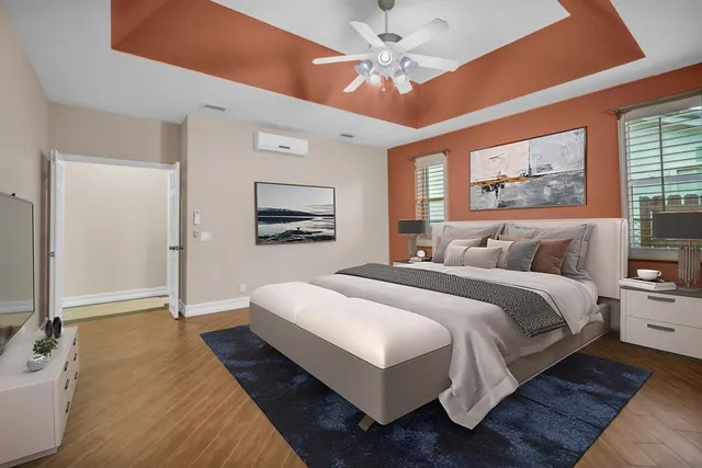 a spacious bedroom with a large bed a chandelier and windows