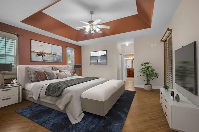 a spacious bedroom with a large bed a chandelier and a couch