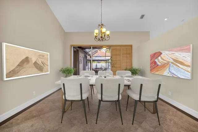a view of a dining room with furniture a chandelier and a window