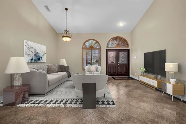 a living room with furniture a large window and a flat screen tv