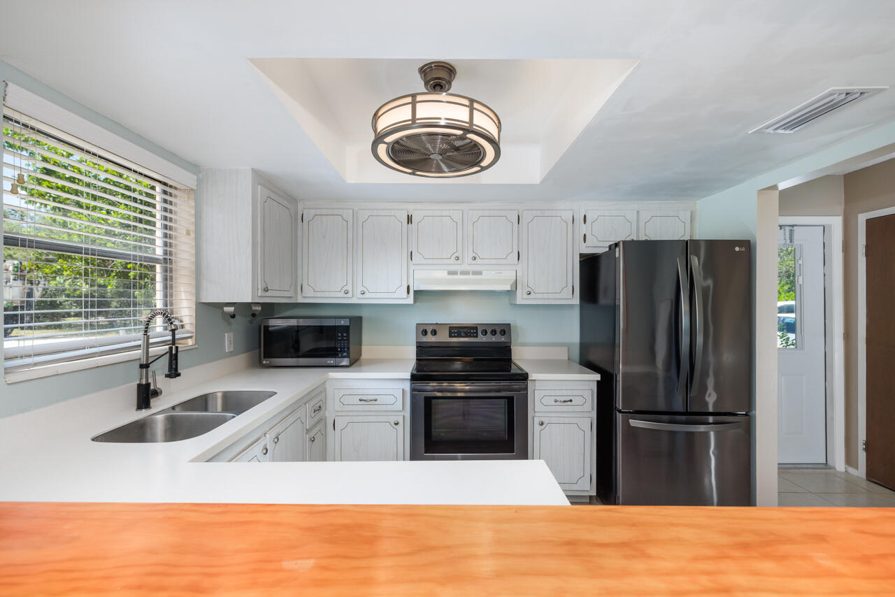2950 Southeast Ocean Boulevard, Unit 533 Stuart, FL 34996 - Photo 11 of 34 a kitchen with stainless steel appliances granite countertop a sink a stove a refrigerator and a microwave