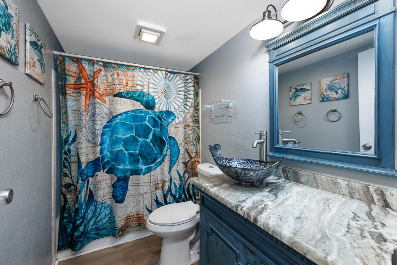 2950 Southeast Ocean Boulevard, Unit 533 Stuart, FL 34996 - Photo 16 of 34 a bathroom with a granite countertop sink mirror vanity and toilet