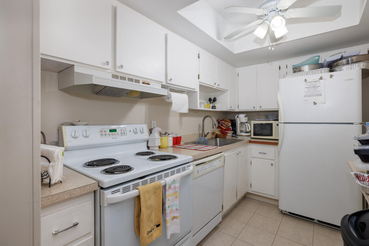 2950 Southeast Ocean Boulevard, Unit 533 Stuart, FL 34996 - Photo 28 of 34 a kitchen with a white cabinets and white appliances