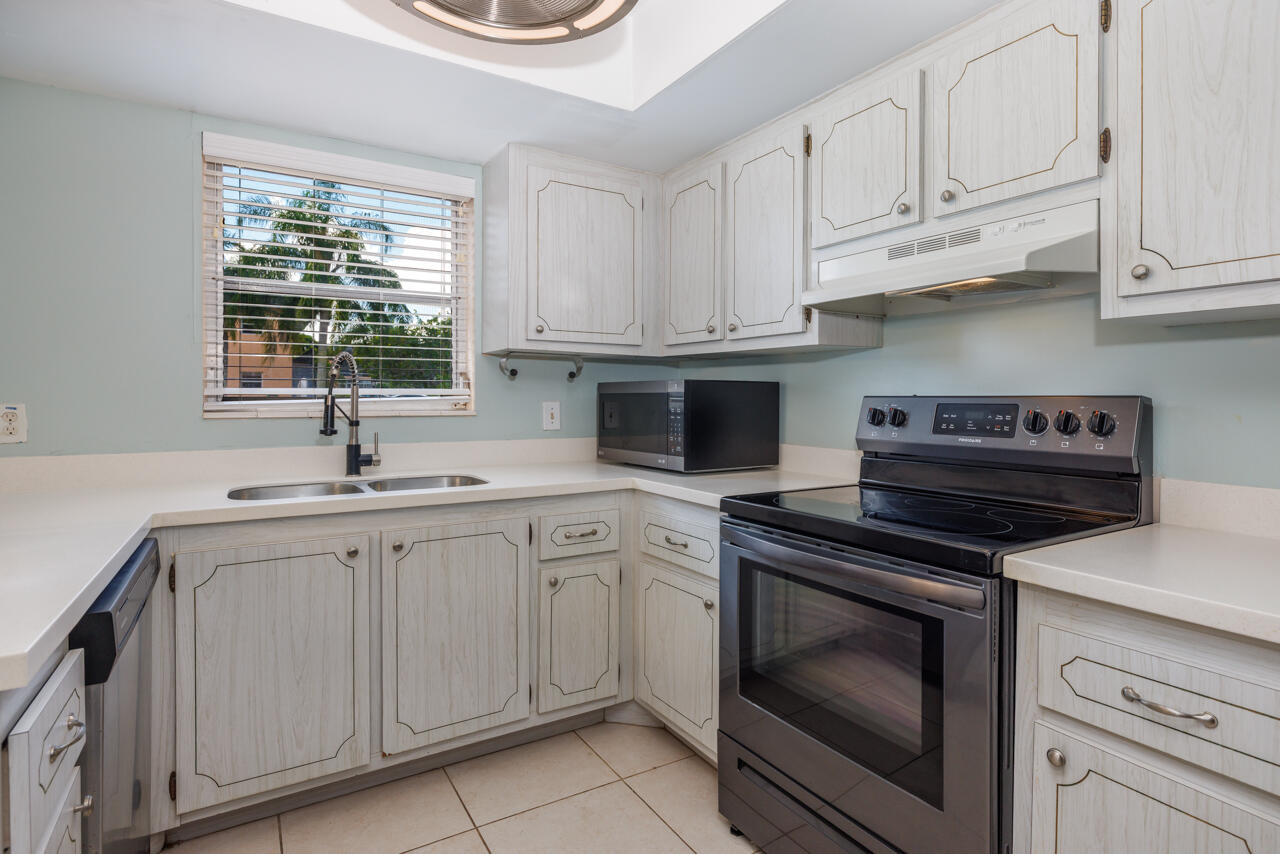 2950 Southeast Ocean Boulevard, Unit 533 Stuart, FL 34996 - Photo 6 of 34 a kitchen with white cabinets and appliances