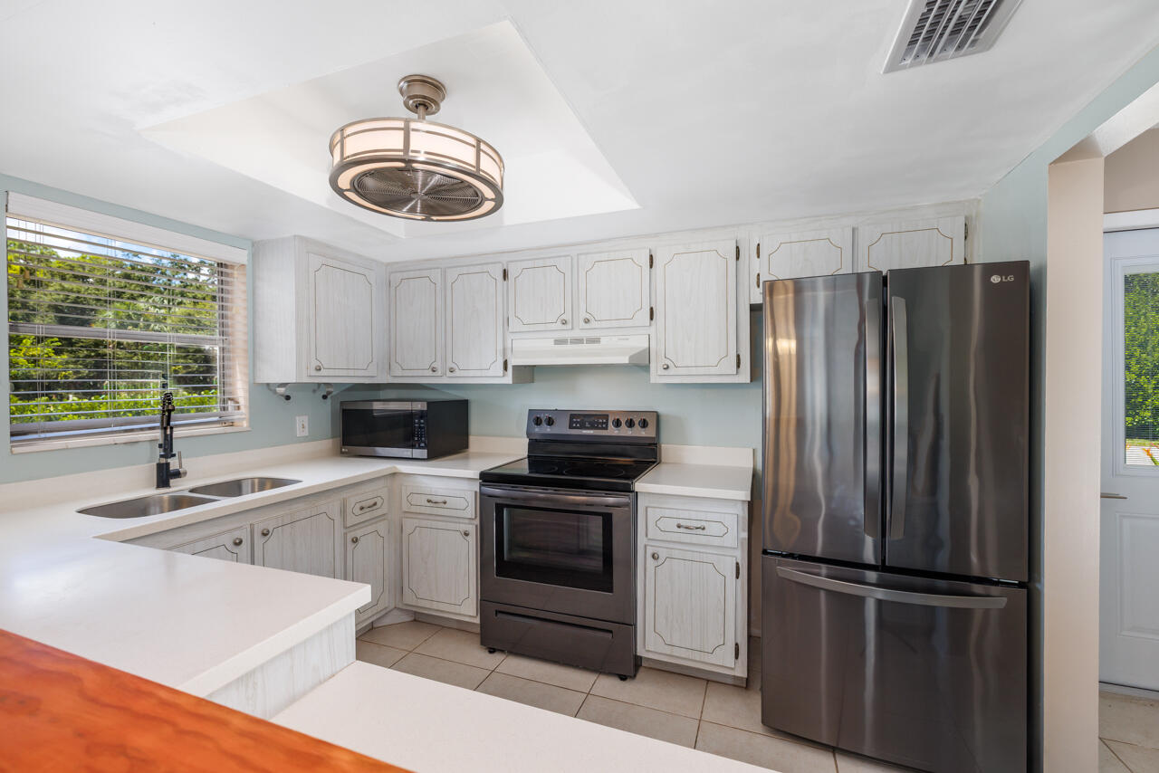 2950 Southeast Ocean Boulevard, Unit 533 Stuart, FL 34996 - Photo 8 of 34 a kitchen with a refrigerator sink and cabinets
