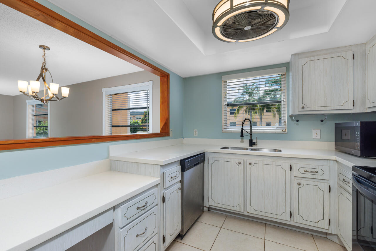 2950 Southeast Ocean Boulevard, Unit 533 Stuart, FL 34996 - Photo 9 of 34 a kitchen with a sink dishwasher a stove and white cabinets