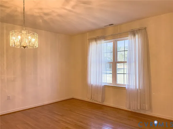 a view of a livingroom with wooden floor and chandelier