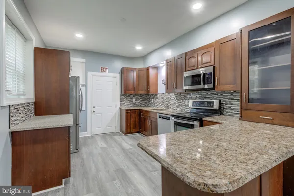 a kitchen with stainless steel appliances granite countertop wooden cabinets and granite counter tops
