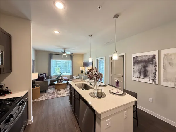 a kitchen with a sink stove and wooden floor
