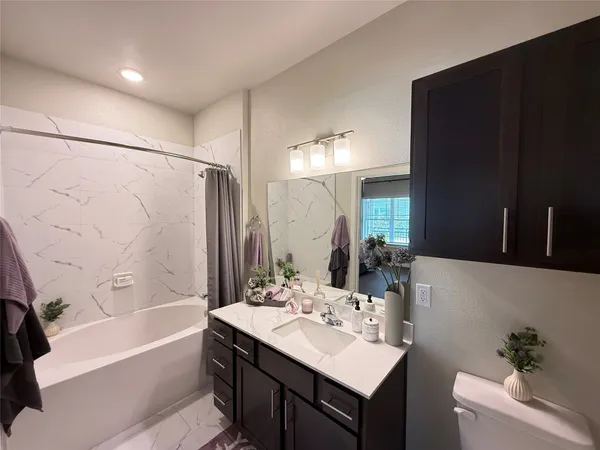 a bathroom with a sink toilet tub and shower