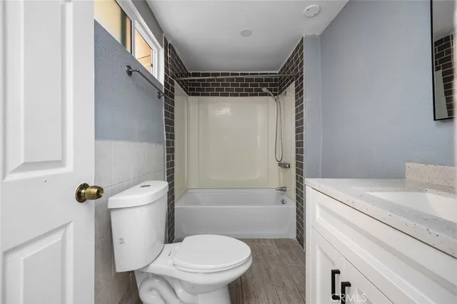a bathroom with a granite countertop toilet sink and shower