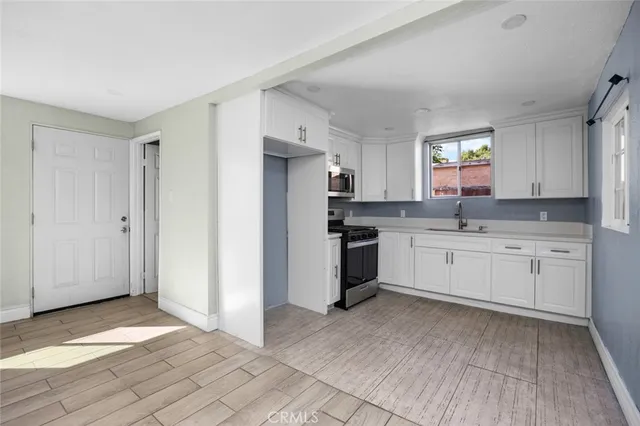 a kitchen with granite countertop white cabinets and white appliances