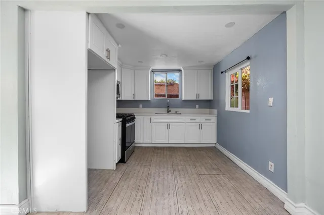 a view of kitchen with granite countertop a sink cabinets and stainless steel appliances